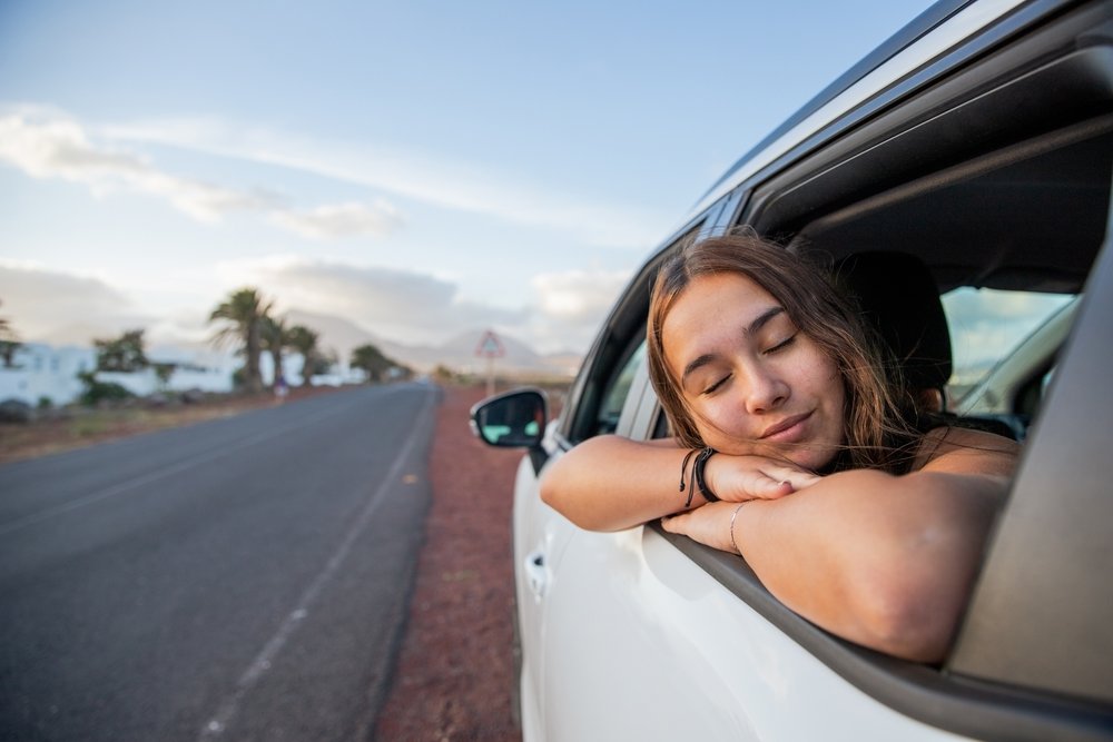 Chica recostada en la ventanilla del coche